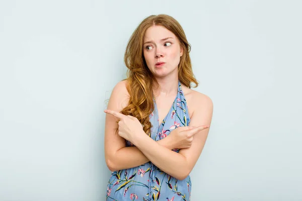 Young Caucasian Woman Isolated Blue Background Points Sideways Trying Choose — Stock Photo, Image