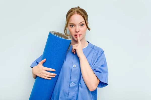 Young Caucasian Physiotherapist Holding Mat Isolated Blue Background Keeping Secret — Stock Photo, Image