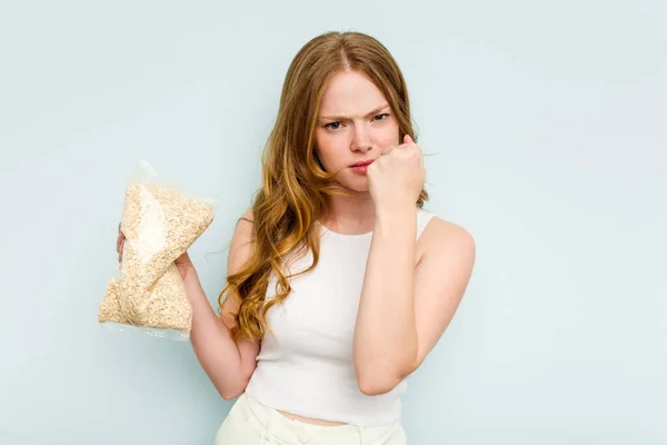 Young Caucasian Woman Holding Oatmeal Isolated Blue Background Showing Fist — Stock Photo, Image