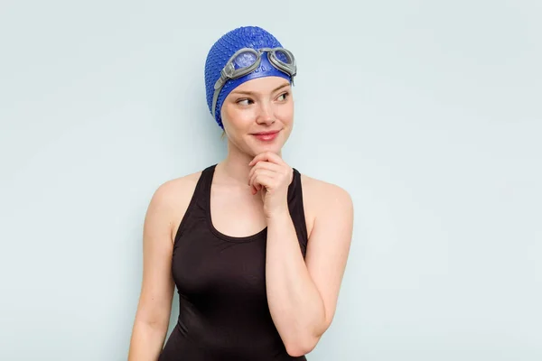 Jovem Nadadora Caucasiana Isolada Fundo Azul Olhando Para Lados Com — Fotografia de Stock
