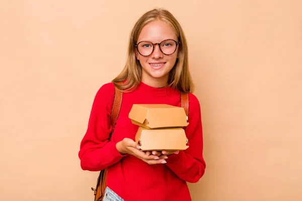 小高加索女学生拿着因米色背景而被隔离的汉堡包笑着玩得开心 — 图库照片