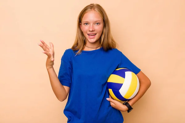 小さいですCaucasian女の子プレイバレーボール孤立でベージュ背景受信A楽しい驚き 励起と上げ手 — ストック写真