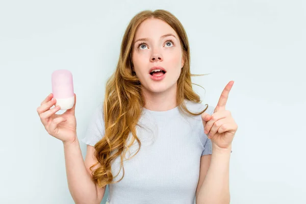 Young Caucasian Woman Holding Deodorant Isolated Blue Background Pointing Upside — ストック写真