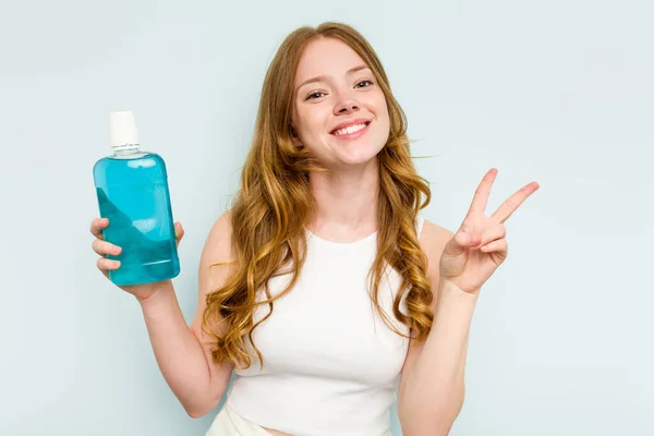 Jonge Blanke Vrouw Met Een Mondwater Geïsoleerd Blauwe Achtergrond Vrolijk — Stockfoto