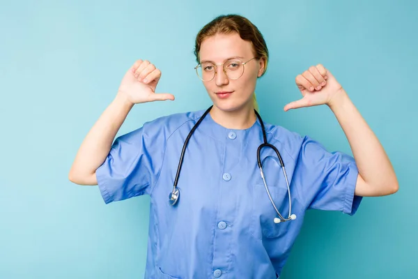 年轻的护士高加索女人被隔离在蓝色背景下 感到自豪和自信 值得学习 — 图库照片