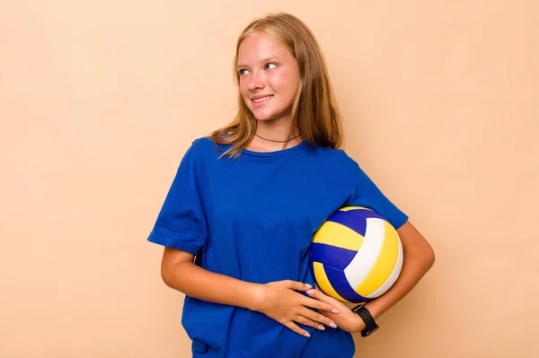 小さなCaucasian女の子プレイバレーボール孤立した上ベージュの背景は脇に笑顔 陽気で楽しい — ストック写真