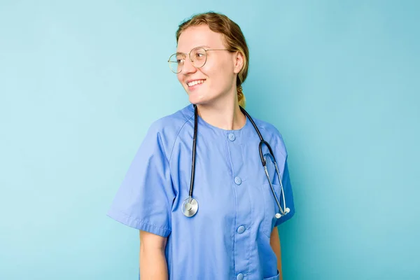Ung Sjuksköterska Kaukasisk Kvinna Isolerad Blå Bakgrund Ser Sidan Leende — Stockfoto