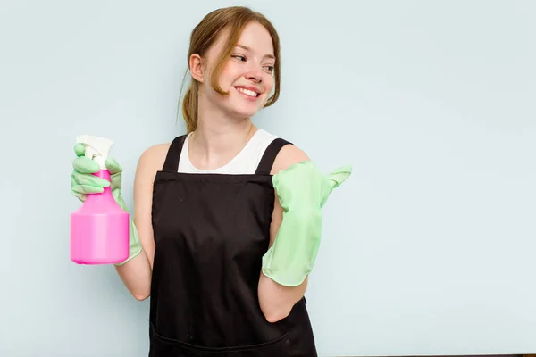 Young Cleaner Woman Isolated Blue Background Points Thumb Finger Away — Stock Photo, Image
