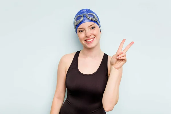 年轻的高加索游泳女子 身披蓝色背景 快乐无忧无虑 用手指展示和平的象征 — 图库照片