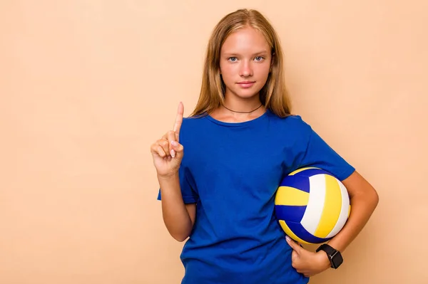 Маленька Біла Дівчинка Грає Волейбол Ізольовано Бежевому Фоні Показуючи Номер — стокове фото