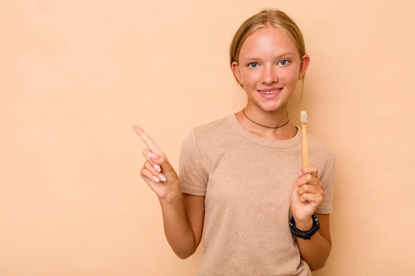 Branco Teen Menina Escovação Dentes Isolado Bege Fundo Sorrindo Apontando — Fotografia de Stock