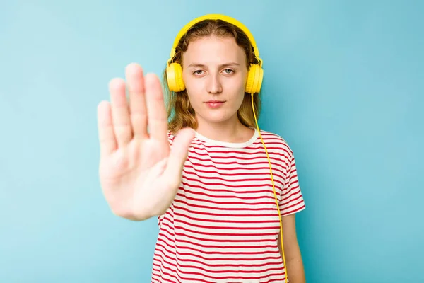 Młoda Kaukaska Kobieta Nosi Słuchawki Odizolowane Niebieskim Tle Stojąc Wyciągniętą — Zdjęcie stockowe