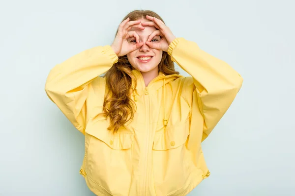 stock image Young caucasian woman isolated on blue background excited keeping ok gesture on eye.