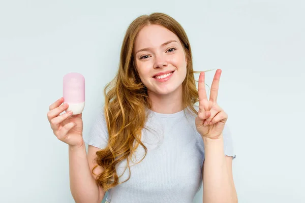 Jonge Blanke Vrouw Met Deodorant Geïsoleerd Blauwe Achtergrond Toont Nummer — Stockfoto