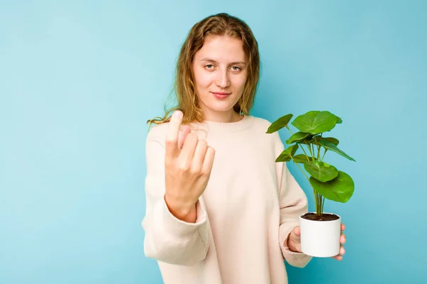 Mulher Caucasiana Jovem Segurando Uma Planta Isolada Fundo Azul Apontando — Fotografia de Stock
