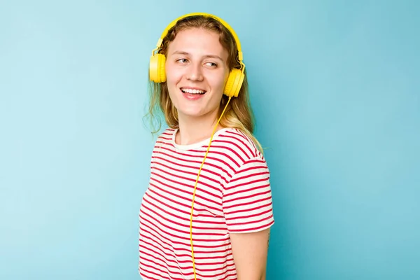 Νεαρή Καυκάσια Γυναίκα Που Φοράει Ακουστικά Απομονωμένα Μπλε Φόντο Κοιτάζει — Φωτογραφία Αρχείου