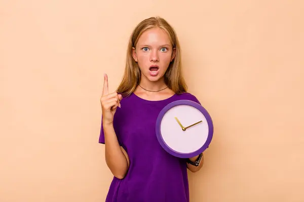 Menina Caucasiana Segurando Relógio Isolado Fundo Bege Ter Alguma Grande — Fotografia de Stock