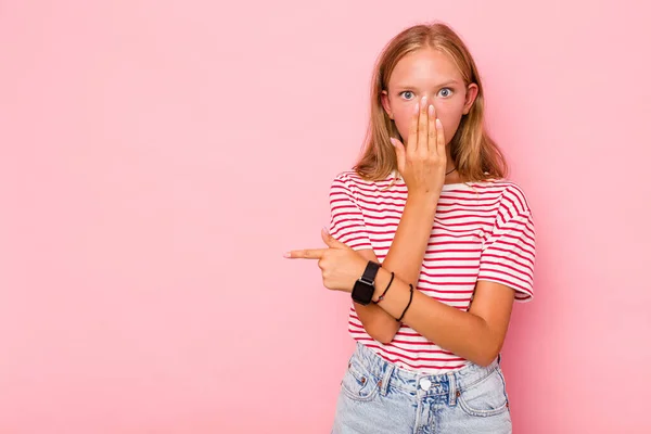 stock image Caucasian teen girl isolated on pink background pointing to the side