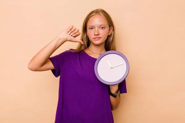 Pequeña Chica Caucásica Sosteniendo Reloj Aislado Sobre Fondo Beige Siente —  Fotos de Stock