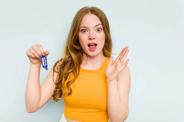 Young Caucasian Woman Holding Home Keys Isolated Blue Background Surprised — Stok fotoğraf