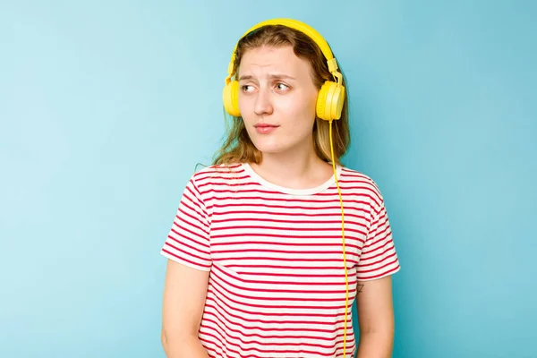 Νεαρή Καυκάσια Γυναίκα Φορώντας Ακουστικά Απομονωμένα Μπλε Φόντο Συγχέεται Αισθάνεται — Φωτογραφία Αρχείου