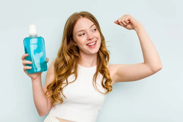 Young Caucasian Woman Holding Mouthwash Isolated Blue Background Raising Fist — Stock Photo, Image