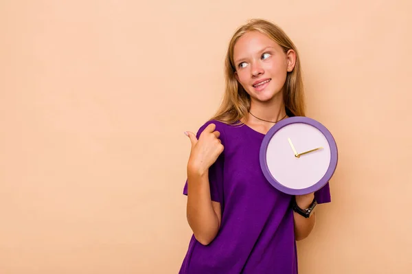 Menina Caucasiana Segurando Relógio Isolado Pontos Fundo Bege Com Dedo — Fotografia de Stock