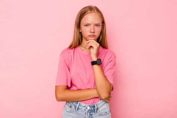 Stock image Caucasian teen girl isolated on pink background suspicious, uncertain, examining you.