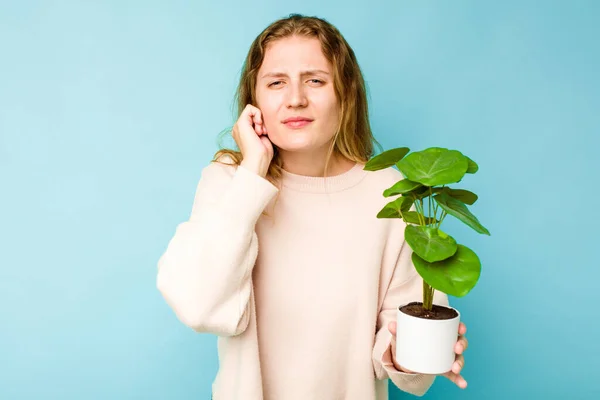 Mladá Běloška Drží Rostlina Izolované Modrém Pozadí Zakrývající Uši Rukama — Stock fotografie