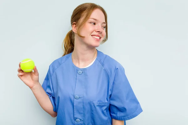 Giovane Fisioterapista Caucasico Possesso Una Palla Tennis Isolata Sfondo Blu — Foto Stock