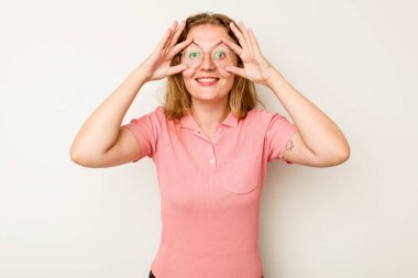 Beyaz arka planda izole genç beyaz kadın bir başarı fırsatı bulmak için gözlerini açık tutuyor..