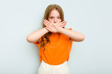 Mavi arka planda izole edilmiş genç beyaz bir kadın inkar jesti yapıyor.