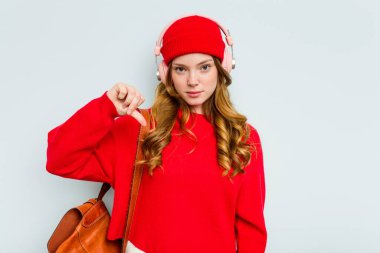 Mavi arka planda izole edilmiş kulaklık takan genç bir bayan hoşlanmadığı bir jest gösteriyor. Anlaşmazlık konsepti.