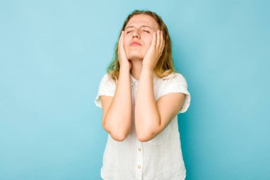 Beyaz bir kadın mavi arka planda yalnız başına sızlanıyor ve ağlıyordu..