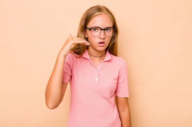 Kafkasyalı genç kız bej arka planda izole edilmiş bir şekilde bir şeye gülüyor, ağızlarını ellerle kapatıyor..