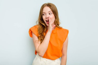 Mavi arka planda izole edilmiş beyaz bir kadın heyecanlı bir şekilde bağırıyor..