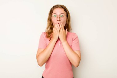 Beyaz arka planda izole edilmiş genç beyaz kadın şok olmuş, elleri ağızda, yeni bir şey keşfetmeye hevesli..