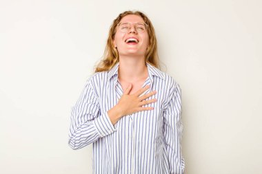 Beyaz arka planda izole genç beyaz kadın yüksek sesle gülüyor elini göğsüne koyuyor..