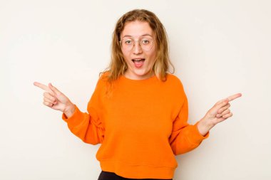 Beyaz arka planda izole edilmiş genç beyaz kadın farklı kopya alanlarını gösteriyor, birini seçiyor, parmaklarıyla gösteriyor.