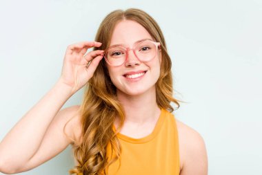 Mavi arka planda izole edilmiş gözlüklü güzel beyaz kadın portresi.