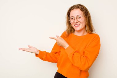 Beyaz arka planda izole edilmiş beyaz tenli genç bir kadın, elinde bir fotokopi alanı tutarken heyecanlanıyor..