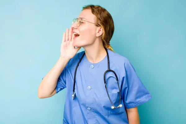 Jovem Enfermeira Caucasiana Isolada Fundo Azul Gritando Segurando Palma Perto — Fotografia de Stock