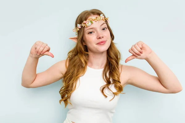 Young elf woman isolated on blue background feels proud and self confident, example to follow.