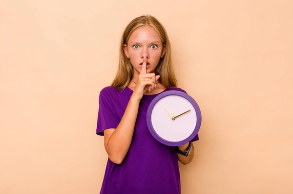 Menina Caucasiana Segurando Relógio Isolado Fundo Bege Mantendo Segredo Pedindo — Fotografia de Stock
