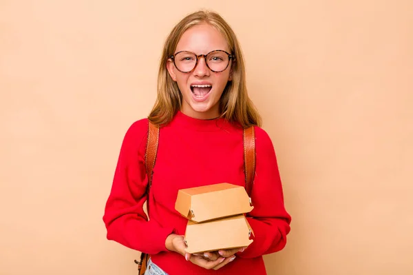一个拿着因米黄色背景而被隔离的汉堡包的高加索女学生怒气冲冲地尖叫着 — 图库照片