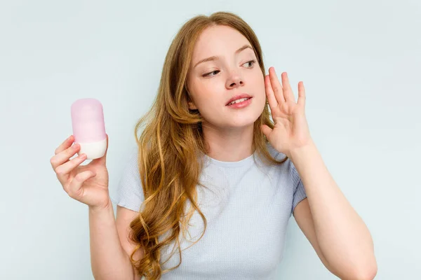 Jonge Kaukasische Vrouw Houden Deodorant Geïsoleerd Blauwe Achtergrond Proberen Luisteren — Stockfoto