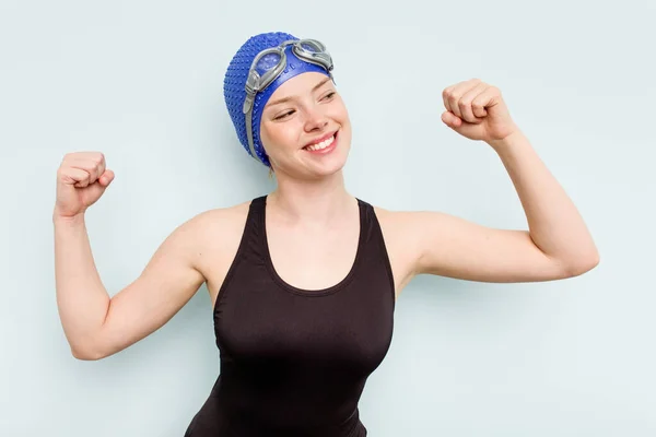 年轻的高加索女子游泳选手在胜利后被蓝色背景隔离举起拳头 获胜的理念 — 图库照片