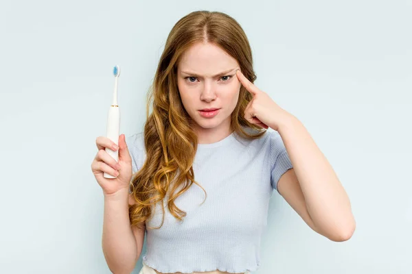 Junge Kaukasische Frau Hält Elektrische Zahnbürste Isoliert Auf Blauem Hintergrund — Stockfoto