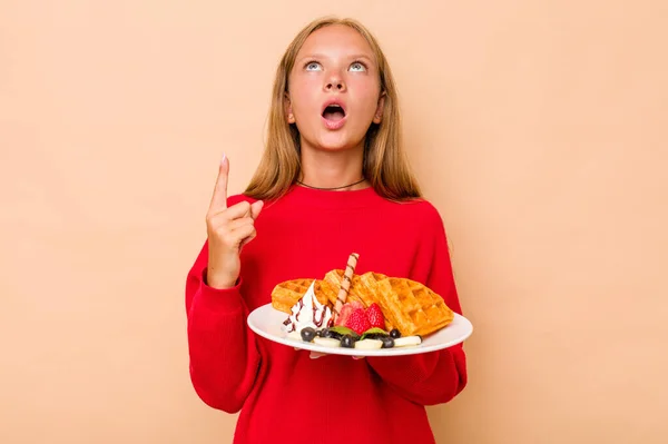 Little Caucasian Girl Holding Waffles Isolated Beige Background Pointing Upside — Stock Photo, Image