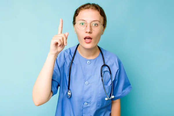 年轻的护士高加索女人 与蓝色背景隔离 有一个想法 灵感的概念 — 图库照片